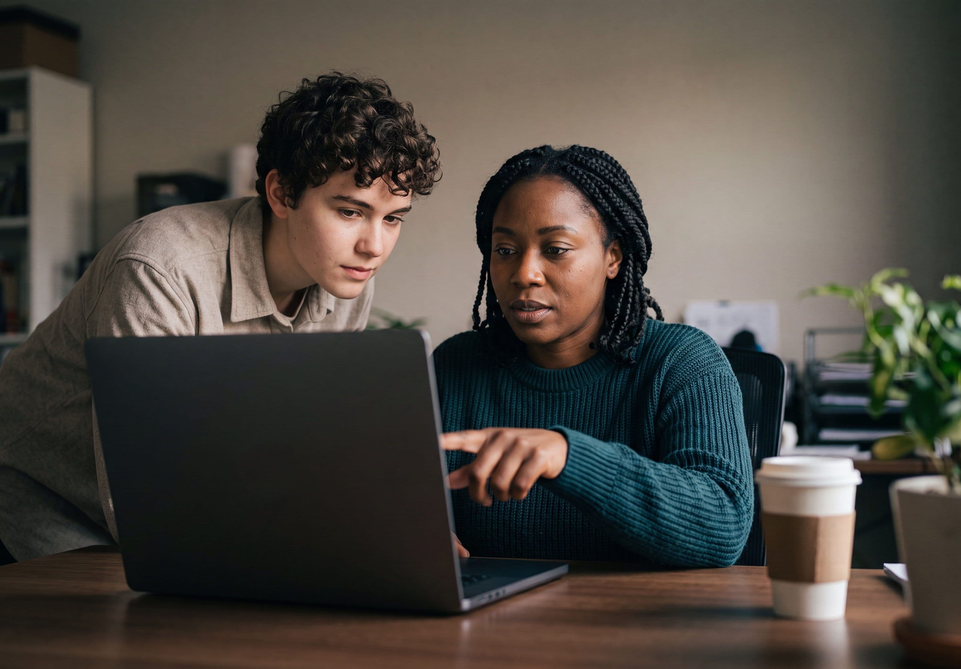 A concierge team member helping an applicant with their rental application at a laptop