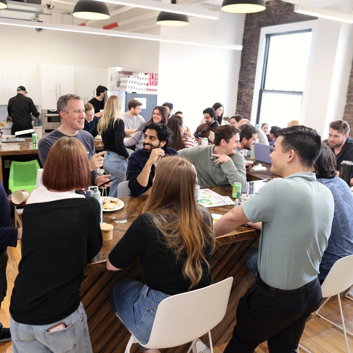 The team gathers around a long communal table for lunch at the New York office